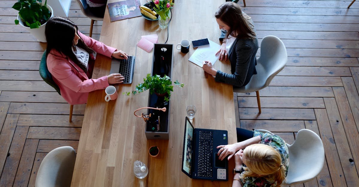 Overhead view of diverse women professionals working in a modern office setting, fostering collaboration and teamwork.