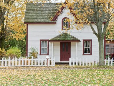 Picturesque traditional house with autumn foliage and a white picket fence in London, Ontario.