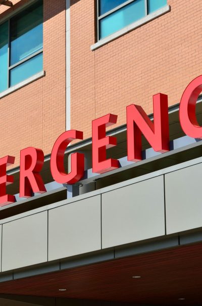 Close-up of a modern hospital emergency room entrance with prominent red letters.