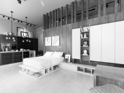 Black and white image of a modern minimalist bedroom with sleek furniture and lighting.