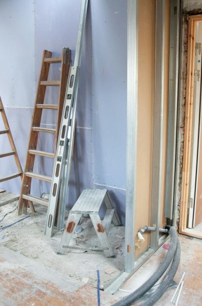 Construction site featuring ladders and tools in a home renovation setting.