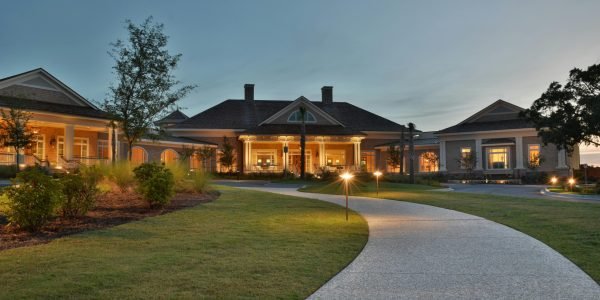 Elegant clubhouse with pathway on Hilton Head Island at twilight, capturing serene architectural beauty.
