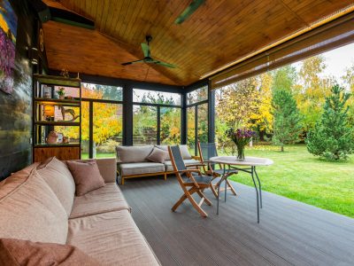 Elegant modern porch with comfortable seating and vibrant garden view.